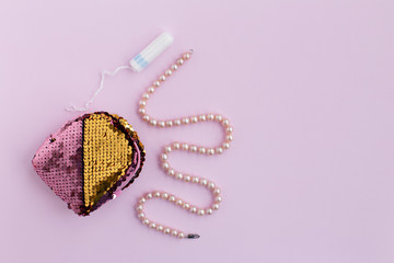 Women's small handbag, cosmetic bag with swab and pearl beads on a pink background