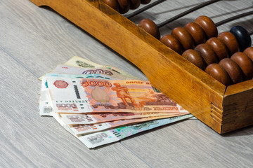 Vintage abacus close-up and ruble banknotes of different denomination.