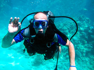 Man scuba diver and beautiful colorful coral reef underwater