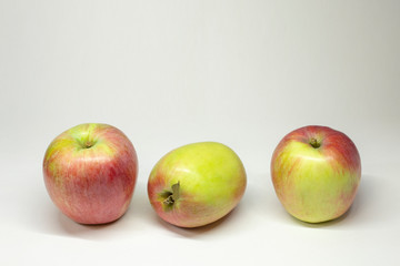 Three ripe apples on the table in the room .  Selective focus. On white background