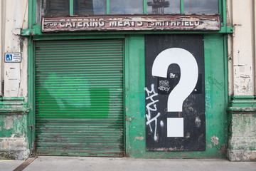 Big interrogation question mark in black and white mural poster on old vintage closed down shop