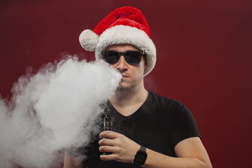 Vaping man in santa claus hat and a cloud of vapor