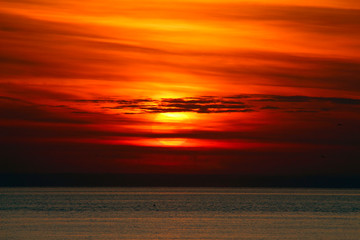 Fototapeta na wymiar setting sun in the clouds over the sea