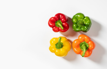Colored bell peppers on white background. Green, yellow, orange and red pepper. Food concept.