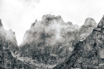 Detail of a mountain rock face, background or wallpaper picture of big wall rock climb, clouds and...