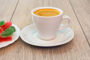 Cup of coffee and multi-colored marmalade.