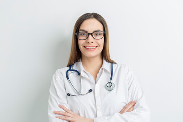 Portrait of a friendly young female professional doctor in a white medical coat.