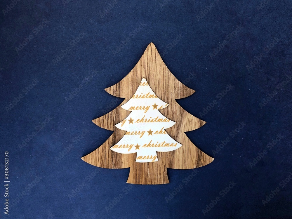 Wall mural decorative wooden decor in the form of a christmas tree on a classic blue color background. place fo