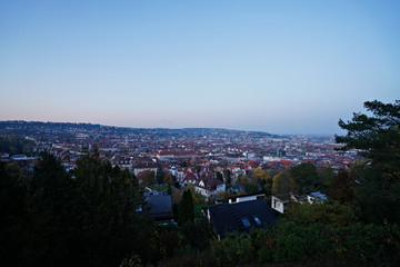Germany, Skyline of city stuttgart in valley surrounded by hills covered by trees