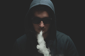 Vaping man with vaporizer and a cloud of vapor