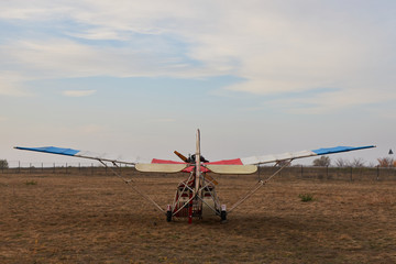 Ultralight aircraft stands on the airfield before takeoff, back view