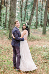 Fototapeta premium Gorgeous wedding rustic couple hugging, smiling and walking in forest