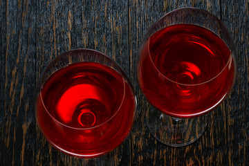 glasses of red wine on a black wooden background, top view.