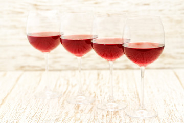 four glasses of red wine on a wooden background, selective focus.