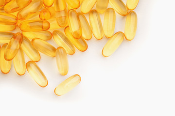 group of yellow fish oil capsules on a white table