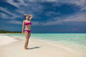 Fototapeta na wymiar Young gorgeous woman in bikini on a tropical island