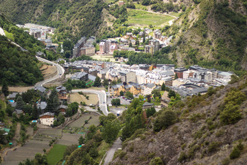 Fototapeta na wymiar A view of Andorra La Vella from a hike high in the mountains around pine trees.