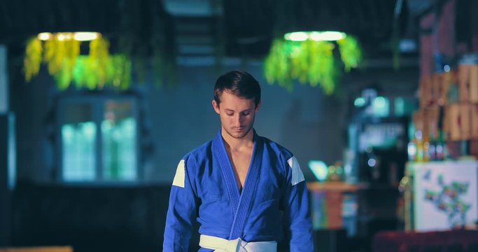 Taekwondo man preparing for battle with the enemy, tuned. Young taekwondo player looks up, a serious look. Portrait view.