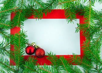 Fototapeta na wymiar It's Christmas time! Red frame on white background with holiday decorations. Top view.