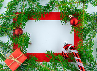 It's Christmas time! Red frame on white background with holiday decorations. Top view.