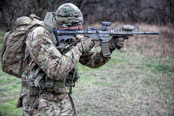 Infantryman aiming rifle during fight in forest