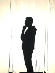 Man backlit in pensive pose
