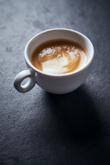 Cup of coffee on dark stone background. Copy space