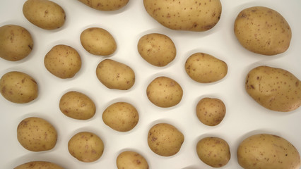 Young white potato, top view. Isolated potatoes on a white background.  Fresh food for vegetarians. Raw vegetable, root vegetable. Photo harvesting potatoes for a designer.