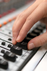 Fototapeta premium Male hand on control Fader on console. Sound recording studio mixing desk with engineer or music producer .
