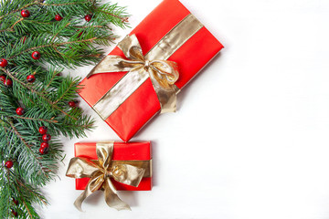 Fototapeta na wymiar Bożonarodzeniowe tło - gałęzie świerku, prezenty i czerwone ozdoby na białym tle