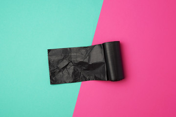 twisted roll with black garbage bags on a colored background