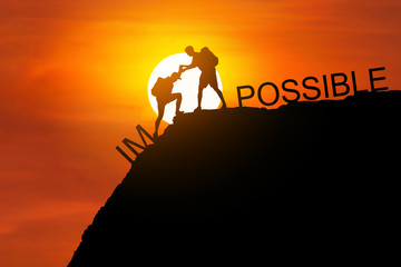 Silhouette two backpackers gives helping hand his friend to climb on high cliff mountain together with text impossible and possible over cliff on sunset background can do it concept. 