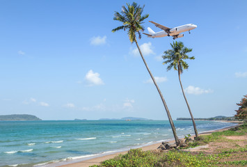 Obraz na płótnie Canvas landscape view of tropical beach with tilted long coconut palm trees slope lean during passenger airplane landing over turquoise sea destinations travel summer holidays concept 