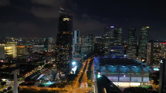 flight over night illuminated singapore city downtown traffic road aerial panorama 4k 