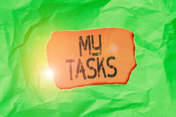 Handwriting text My Tasks. Conceptual photo assigned piece of work often to be finished within a certain time Green crumpled ripped colored paper sheet centre torn colorful background