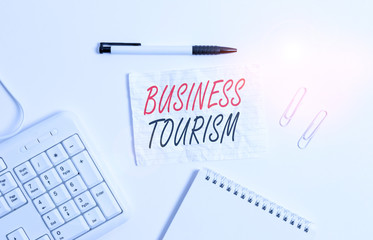 Text sign showing Business Tourism. Business photo showcasing activity of leaving one s is native place for business purpose White pc keyboard with empty note paper and pencil above white background
