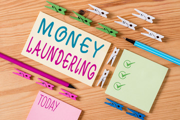 Conceptual hand writing showing Money Laundering. Concept meaning concealment of the origins of illegally obtained money Colored crumpled papers wooden floor background clothespin