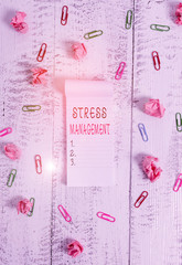 Writing note showing Stress Management. Business concept for learning ways of behaving and thinking that reduce stress Stripped ruled notepad clips paper balls wooden background