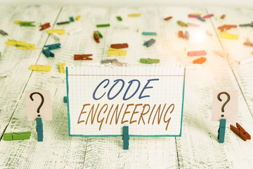 Conceptual hand writing showing Code Engineering. Concept meaning application of engineering to the development of software Crumbling sheet with paper clips placed on the wooden table