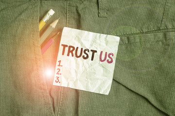 Word writing text Trust Us. Business photo showcasing to believe that someone is good and honest and will not harm Writing equipment and blue note paper inside pocket of man work trousers