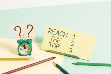 Text sign showing Reach The Top. Business photo text Get Ahead Succeed Prosper Thrive for the Win Victory Mini size alarm clock beside stationary placed tilted on pastel backdrop