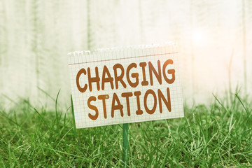 Conceptual hand writing showing Charging Station. Concept meaning places where showing charge their electric equipment Mathematic paper attached to a stick and placed in the grassy land