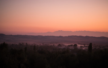 Sunset landscape view of silhouette mountains and lonely trees in Azerbaijan. Sheki
