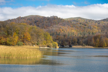 A calm evening landscape with lake and mountains. Amazing view of the Goy-Gol (Blue Lake) Lake among colorful fall forest at Ganja, Azerbaijan.