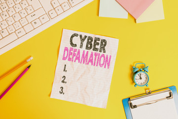 Text sign showing Cyber Defamation. Business photo text slander conducted via digital media usually by Internet Copy space on notebook above yellow background with keyboard on table