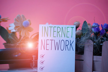 Writing note showing Internet Network. Business concept for connects computers together globally using internet Flowers and writing equipments plus plain sheet above textured backdrop