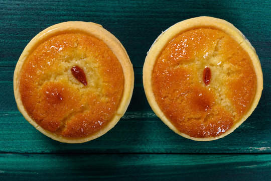 Top View Fresh Cocknut Tarts On Green Wood Table