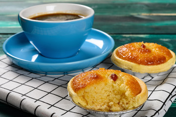 side view fresh cocknut tart with a bite and cup of coffee on back horizontal composition