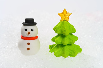 snowman and christmas fir tree on snow