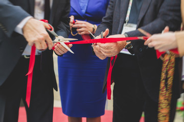 Process of cutting the red ribbon during the grand opening of the new shopping center mall...